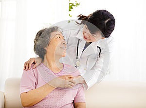 Nurse holding hand of senior woman in rest home