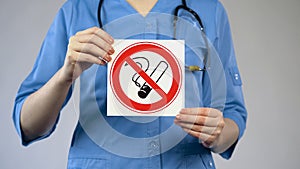 Nurse holding in hands no smoking card, harmful habit, medicine and healthcare