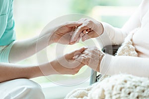 Nurse holding patient`s hands