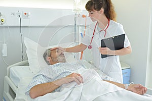 nurse holding sicks man forehead photo