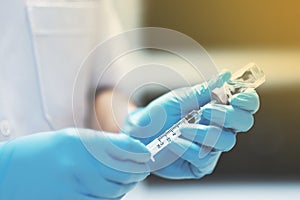 Nurse holding syringe and vaccine for injection photo