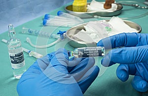Nurse holds ampoule of anesthesia, preparation to extract cerebrospinal fluid to investigate causes in a person affected by photo