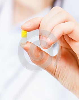 Nurse holds pilule in finger