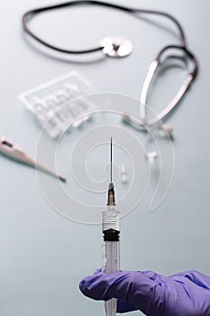 A nurse holds a syringe with a vaccine on a blue background. Vaccination. COVID-19, SARS - CoV2 Vaccine concept.