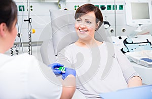 Nurse in hospital checking access at woman blood donor