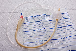 Nurse inflates urinary catheter bulb with leg drainage bag on sterile field. photo