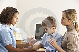 Nurse injecting child with mother photo
