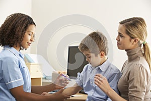 Nurse injecting child with mother