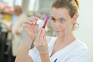 Nurse labeling blood in vacuum tube
