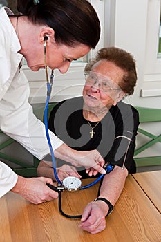 Nurse looks old woman in a nursing home