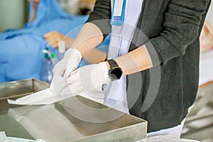 The nurse with lots of medicine is preparing or cleaning the stitch of her woman patient after surgery in the patient department