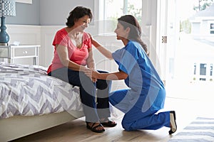 Nurse Making Home Visit To Senior Hispanic Woman