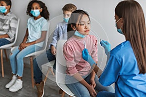 Nurse Making PCR Test For Asian Girl, Testing Children Indoors