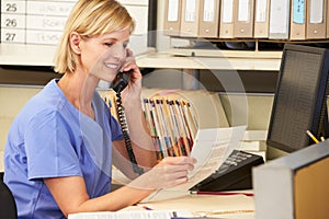 Nurse Making Phone Call At Nurses Station