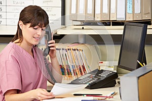 Nurse Making Phone Call At Nurses Station