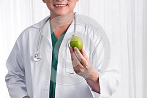 Nurse or male doctor giving an apple smiling. Health care concept isolated on white background.