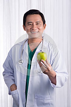 Nurse or male doctor giving an apple smiling. Health care concept on white background.