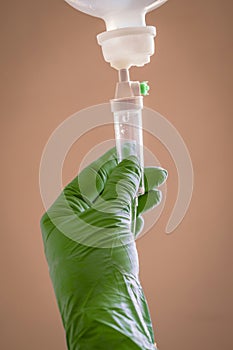 Nurse managing fluid with a dropper on brown background