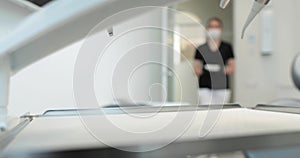 A nurse in a mask carries a tray with disinfected instruments to start a dental surgery.