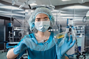 nurse in mask and gloves holding a syringe with medicine and waiting for a patient in surgery.