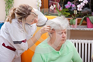 Nurse massages the head of a senior