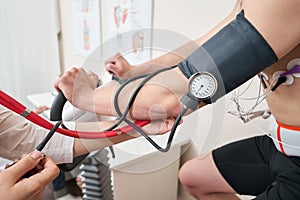 The nurse measures arterial tension. Man patient, pedaling on a bicycle ergometer stress test system for the function of