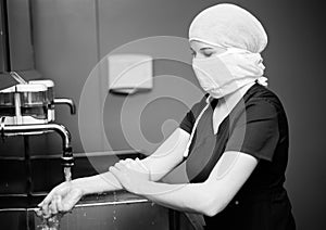 Nurse in medical mask washes hands