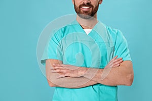 Nurse in medical uniform on light blue background, closeup