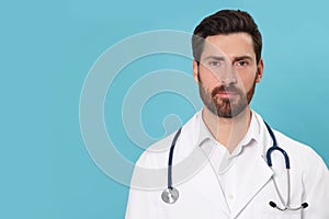 Nurse in medical uniform with stethoscope on light blue background, space for text