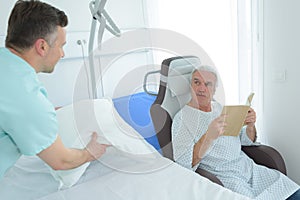 Nurse next to patient reading book