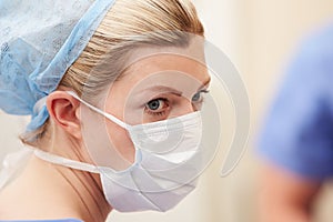 Nurse In Operating Theatre Wearing Scrubs And Mask