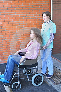 Nurse and patient in wheelchair in front of main photo