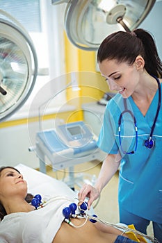 Nurse performing an electrocardiogram test on the patient