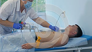 Nurse performing electrocardiography on a male patient