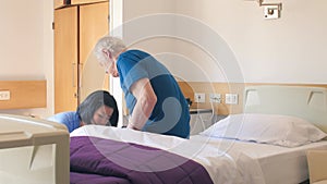 A nurse prepares bed for elderly people