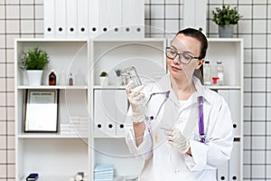 The nurse prepares a dropper with a solution of medicine.