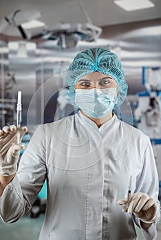 A nurse prepares an injection in the operating room. Surgeon in operating theatre