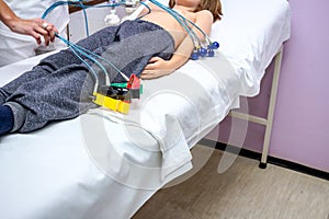 Nurse is preparing a child, teenager patient for ECG or EKG test