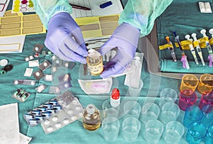 Nurse preparing hospital medication, placing dose medicine in glass monodose, conceptual image