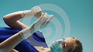 nurse preparing a syringe for an injection vertical video studio shot medium closeup blue background medical concept