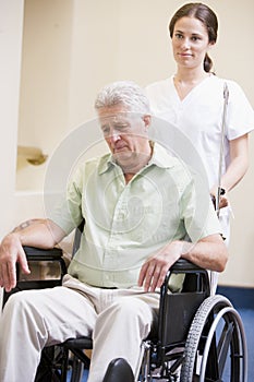 Nurse Pushing Man In Wheelchair