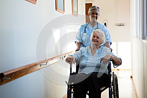 Nurse pushing patient sitting in wheelchair at nursing home