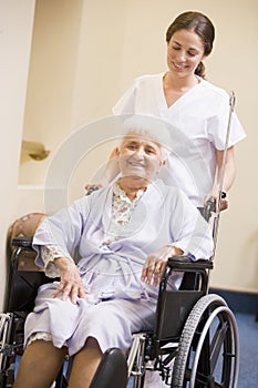 Nurse Pushing Senior Woman In Wheelchair