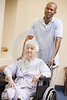 Nurse Pushing Senior Woman In Wheelchair