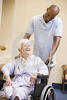 Nurse Pushing Senior Woman In Wheelchair