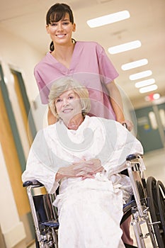 A Nurse Pushing A Senior Woman In A Wheelchair