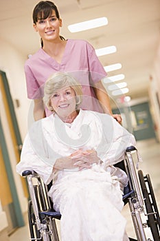 A Nurse Pushing A Senior Woman In A Wheelchair