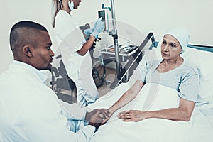 Nurse Puts Dropper. Doctor Holding Patient`s Hand.