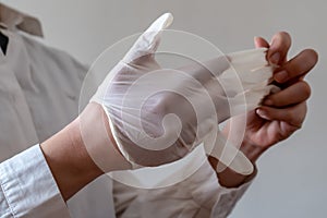 A nurse puts on gloves in order photo