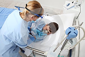 nurse puts oxygen mask on patient child in hospital bed, wearing protective visor mask, corona virus covid 19 protection concept, 